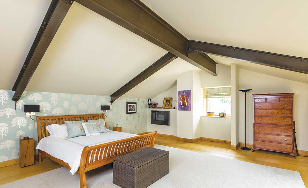 Master bedroom in barn conversion with exposed steel beam