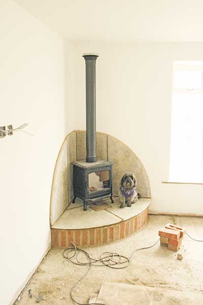 The corner fireplace is built and the woodburning stove installed in David's self build