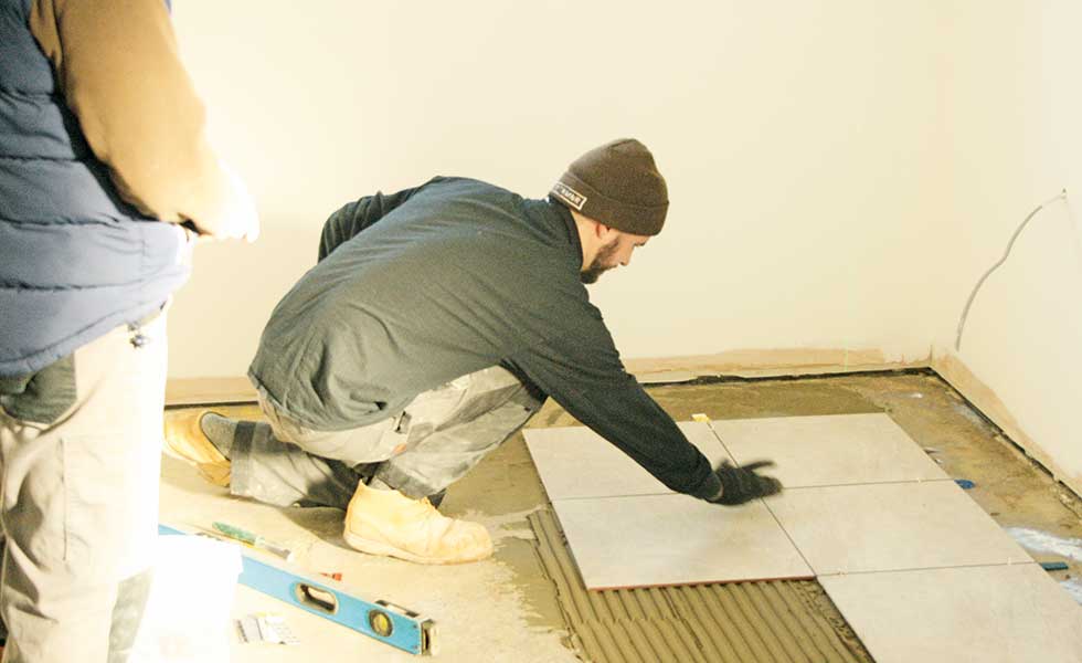 The builders lay the interior floor tiles in David Snell's self build project