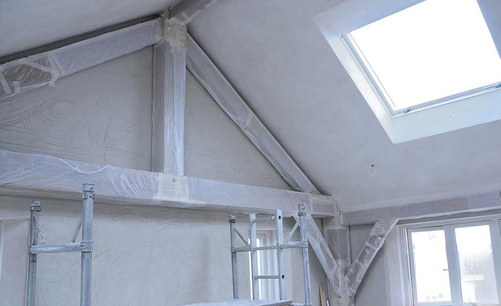 lime plastering the interior of a vaulted ceiling oak frame room