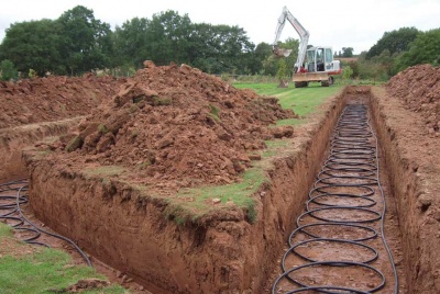 Installing the slinky pipes for a ground source heat pump