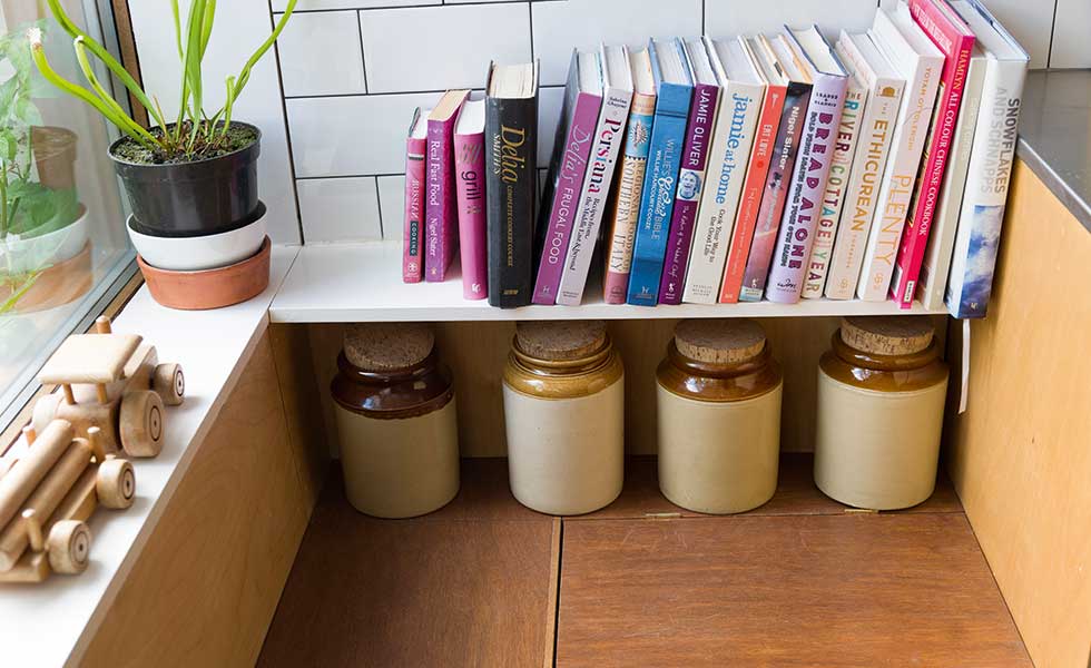 book shelf and concealed storage benches in kitchen window seating