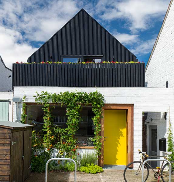 White brick and black painted timber cladding make up the exterior of this newsagents converted into a small sustainable home