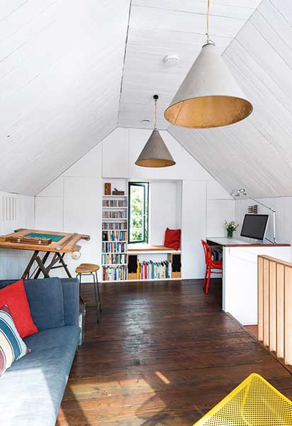 storage wall with window seat in loft room with vaulted ceiling