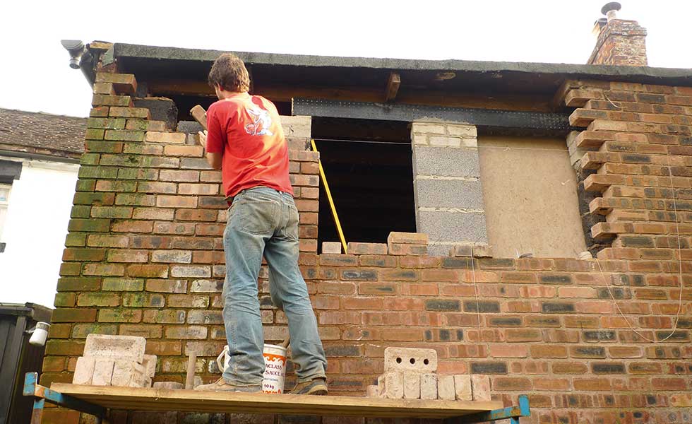 rebuilding the brick walls of a converted newsagents
