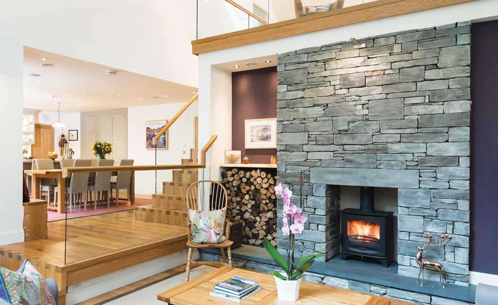 Split level living room with woodturning stove in slate chimney breast