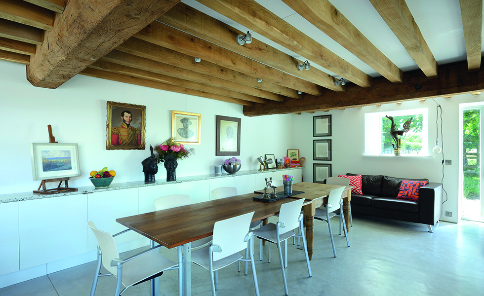 Dining space in barn conversion with polished concrete floors and exposed beams