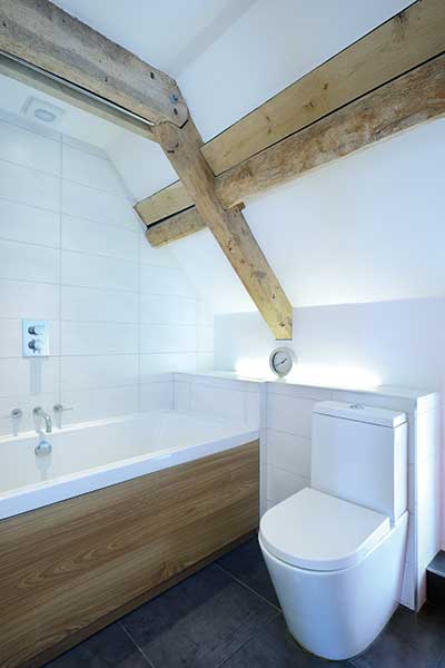 Contemporary bathroom with sloping ceiling and exposed beams