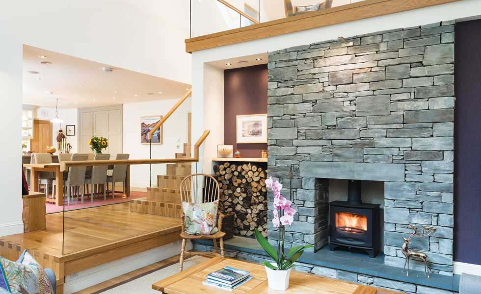 A change in levels adds drama to the living room in this self build project. Stepping down from the more enclosed kitchen with lower ceiling, the impact of the double-height volume in the living room is made even greater. A mezzanine breaks up this space