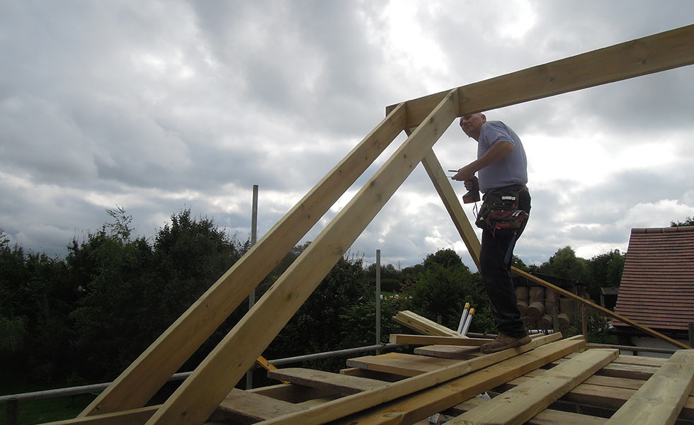 Man fixing timber rafters on a roof