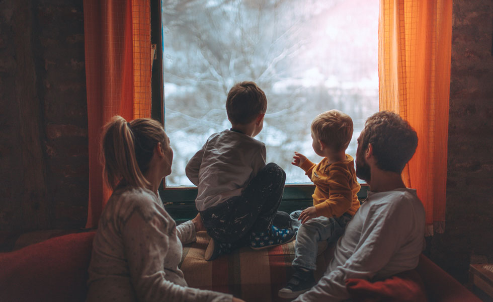 Family huddled together in front of a window