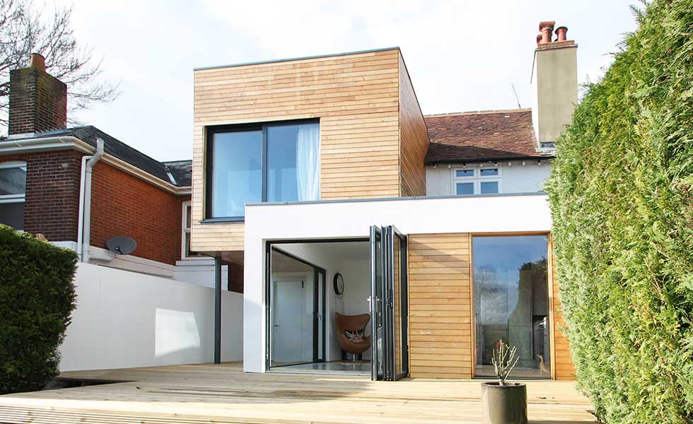 A cantilevered two storey timber clad extension