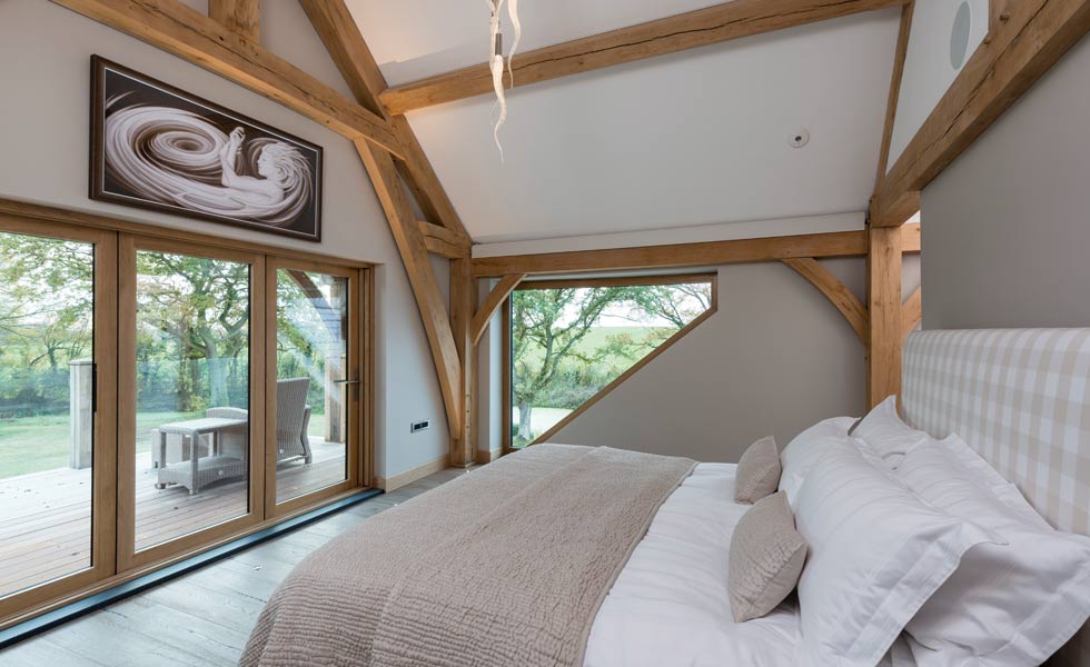 master bedroom with oak beams and bifold doors