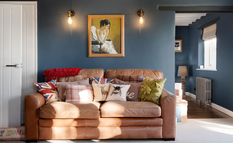 Dark blue living room with tan leather sofa