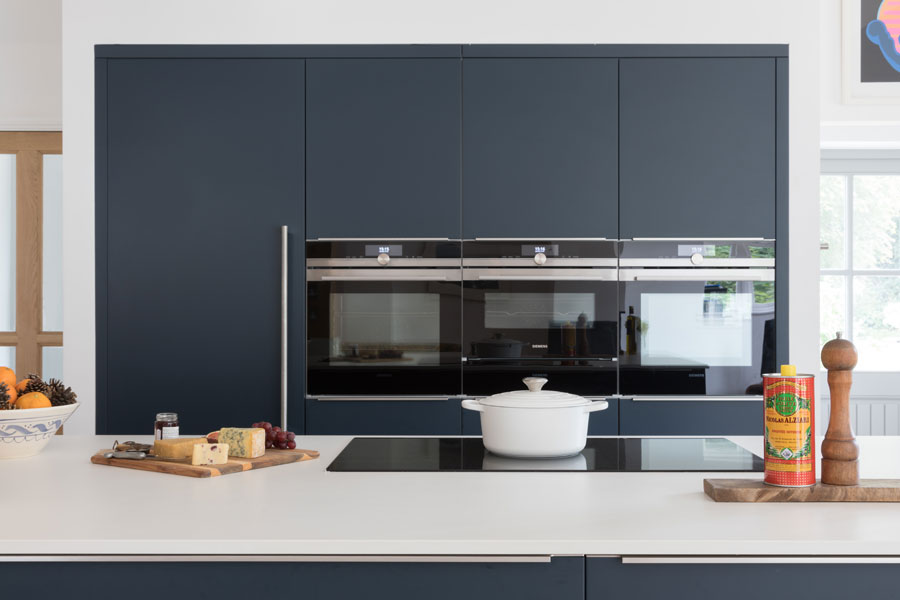 White and navy contemporary kitchen with built-in ovens