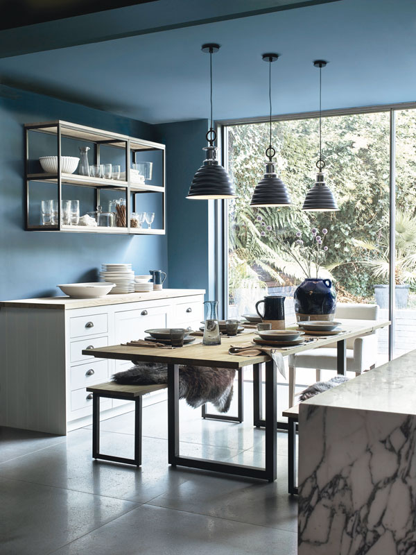 Dark, moody tones, like the blue of this kitchen, help create a cosy ambience