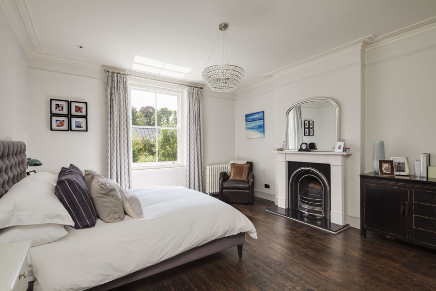 Master bedroom with period fireplace and timber flooring