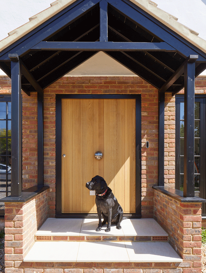 exterior of a home with wooden front door and dog