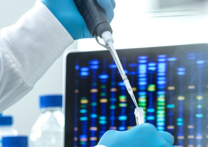 A scientist pipetting a sample into a vial for DNA testing