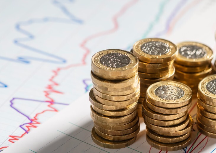 Pound coins with the backdrop of a chart