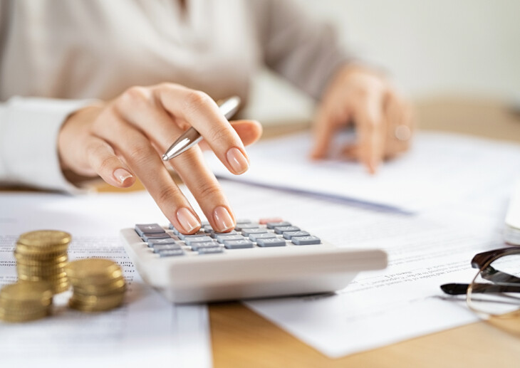 A person using a calculator and calculating budgets.