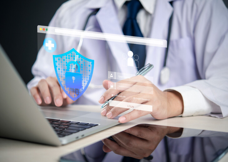A doctor using a laptop with cyber security graphics on top.