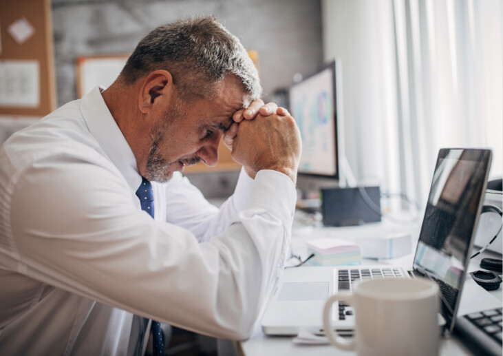A health leader at his desk looking stressed.