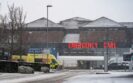 A hospital building in the snow with an ambulance driving past and signs for the emergency department to illustrate a dramatic reduction in hospitalisations from RSV vaccination last winter