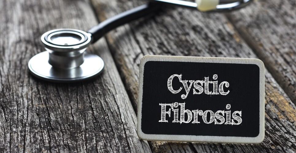 Cystic Fibrosis written on blackboard with a stethoscope behind it on wooden planks to illustrate a once-daily cystic fibrosis treatment being available on the NHS