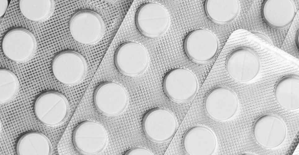 A close up of multiple silver blister packets of medication with white tablets visible through the clear blisters to illustrate research suggesting aspirin use should be discontinued in high-risk patients with chronic coronary syndrome who had prior stenting and were receiving long-term oral anticoagulation due to an increased risk in adverse and fatal outcomes