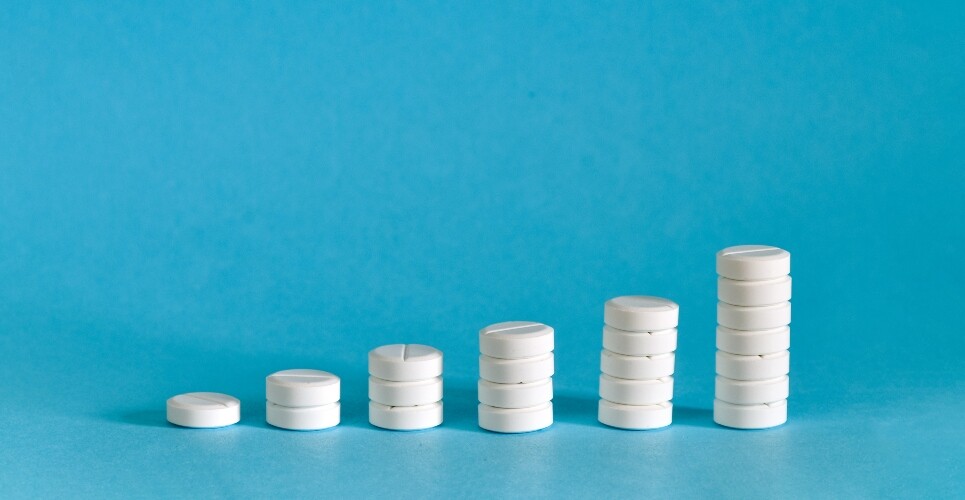 Stacks of white tablets arranged in increasing height on a blue background, forming a bar chart-like progression