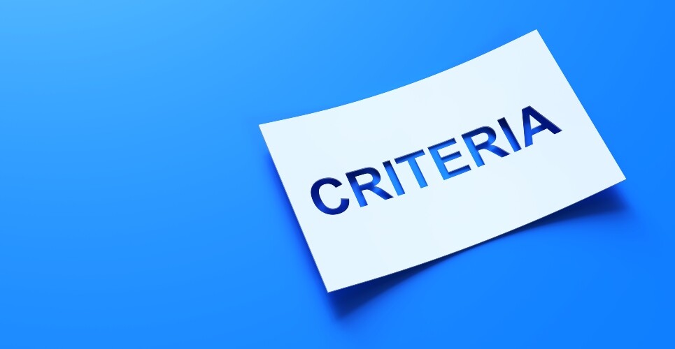 A white piece of paper with the word CRITERIA cut out of it on a blue background to illustrate that minimal disease activity criteria could support treat-to-target care for HS