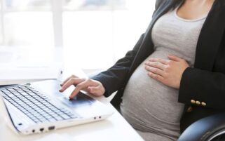 pregnant woman sitting at computer keyboard