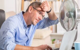 man in office during heatwave with fan