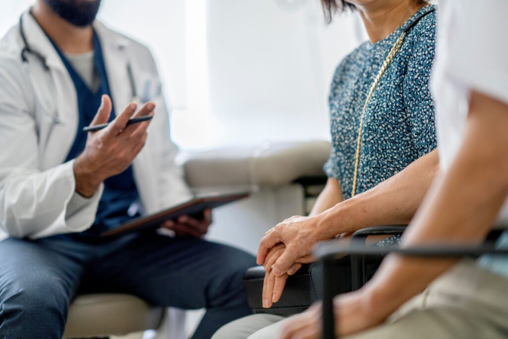 GP speaks to vulnerable patient who is supported by relative