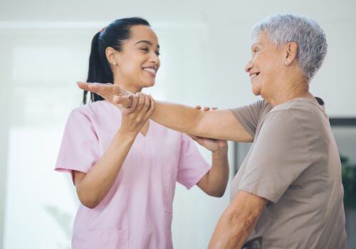 Shot of an older woman doing light stretching exercises during a session with a physiotherapist inside