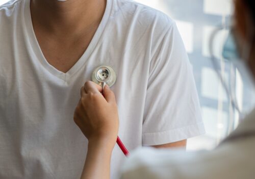 A doctor examines a patient's heart with a stethoscope