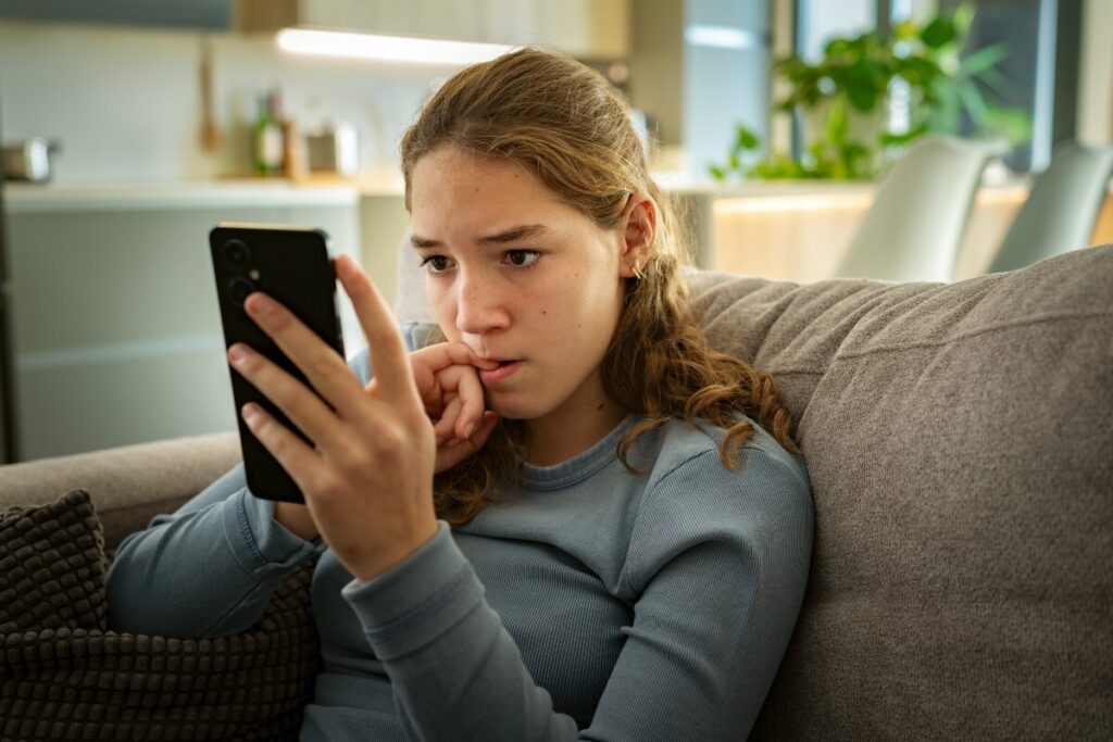 A photo of a teenager looking at her phone