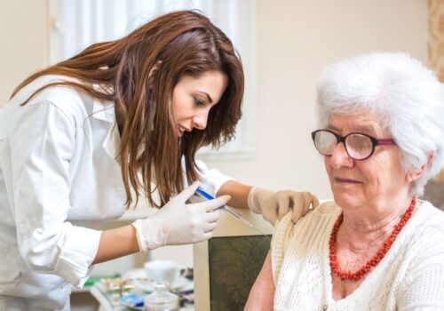 A doctor giving a vaccination to a woman.