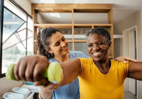 Elderly woman doing physical therapy with dumbbell