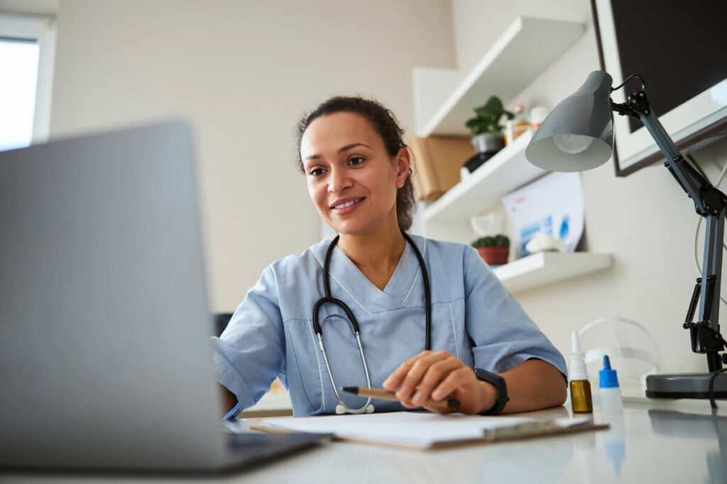 A female GP using a laptop.