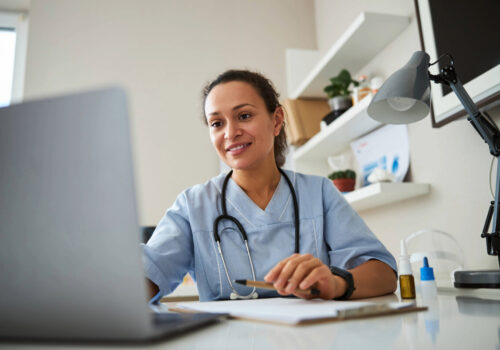 A female GP using a laptop.