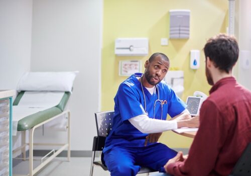 A doctor speaking to a patient in a GP practice.