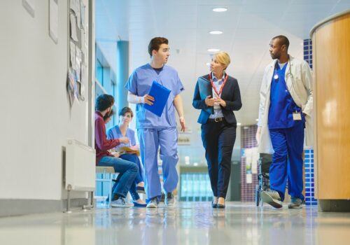 Two physician associates speaking with a medical professional.