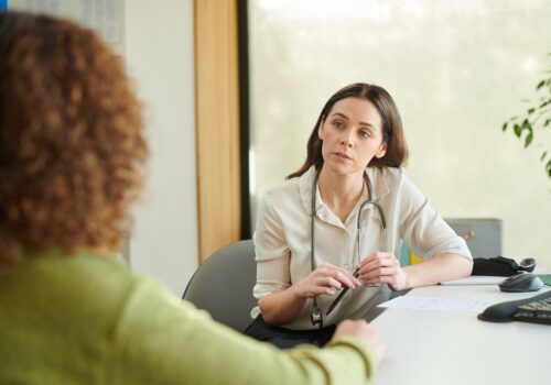 A GP listening to a patient.