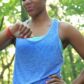 Close-up of top half of young adult Black woman wearing blue running top looking at red Fitbit device on wrist to illustrate clinical scenario with high pulse rate indicating tachycardia