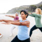 Group of middle-aged women post-menopause taking part in group exercise class outdoors on beach to illustrate holistic menopause care