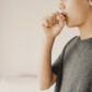 Close-up side view of boy holding hand to open mouth to signify persistent cough in children