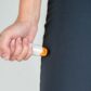 Close-up of woman's hand holding epipen to her thigh for emergency injection for anaphylaxis