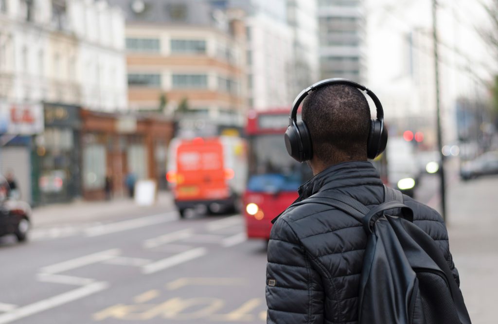 man walking on street listening to headphones